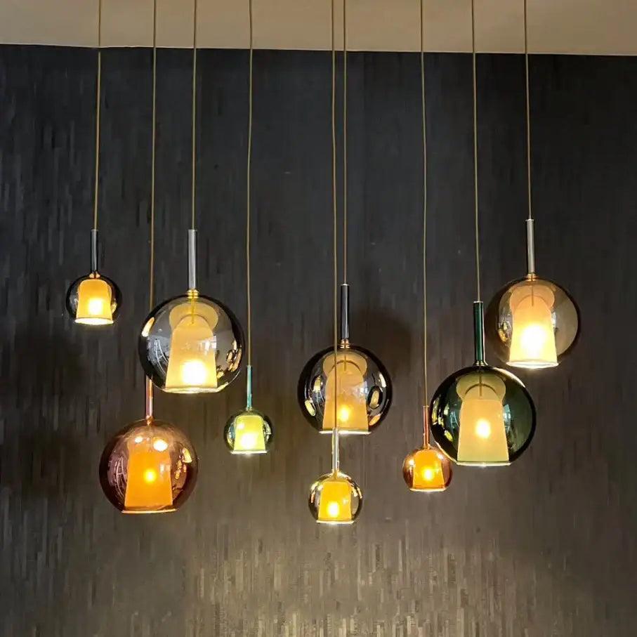 Modern black glass ball pendant lights with warm amber and reflective black hues by decorbites for kitchen island decor