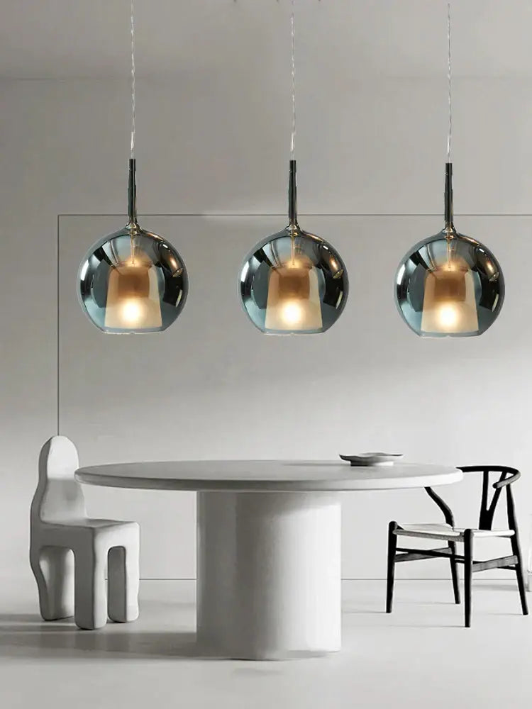 Modern black glass ball pendant lights featuring three sleek chrome decorbites glass ball pendant lights above table