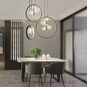 Modern black glass bubble led chandelier with circular pendant lights and clear glass orbs above dining table decorbites glass bubble