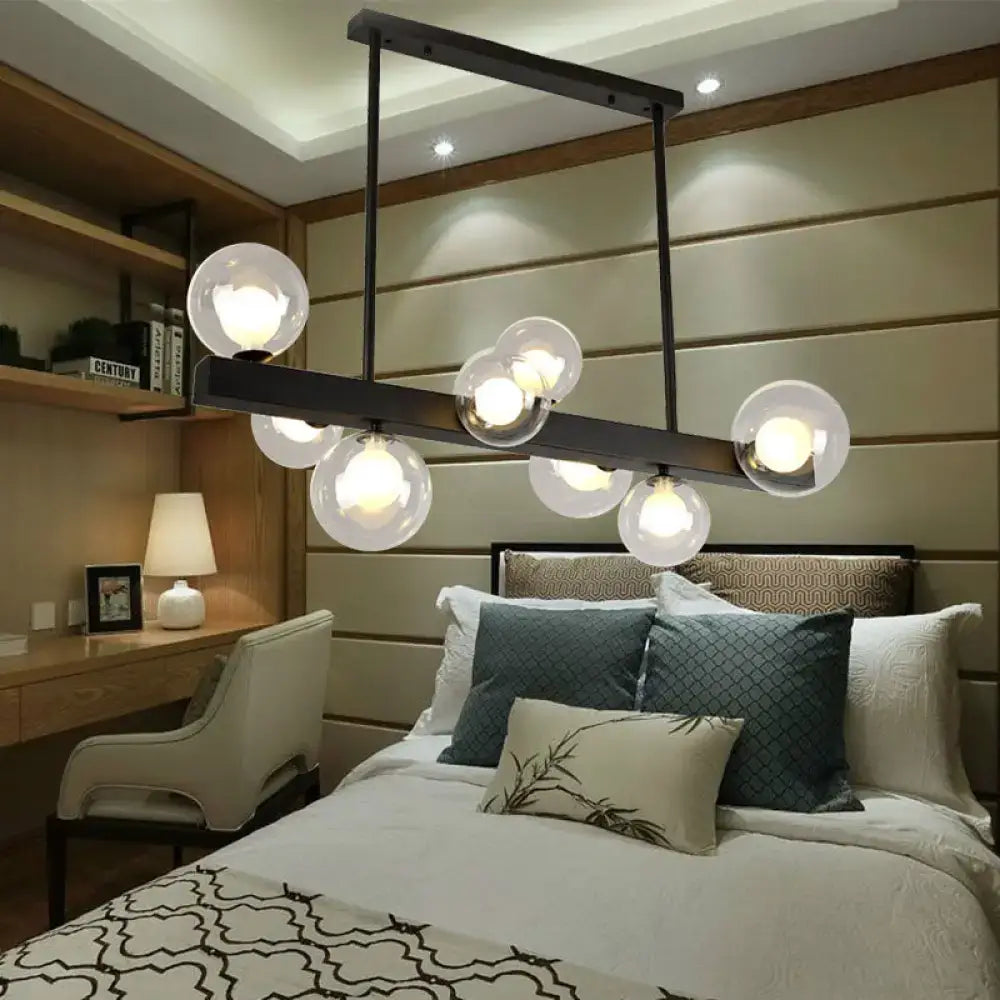Modern black metal chandelier with eight spherical glass globe lights for dining room and kitchen island lighting