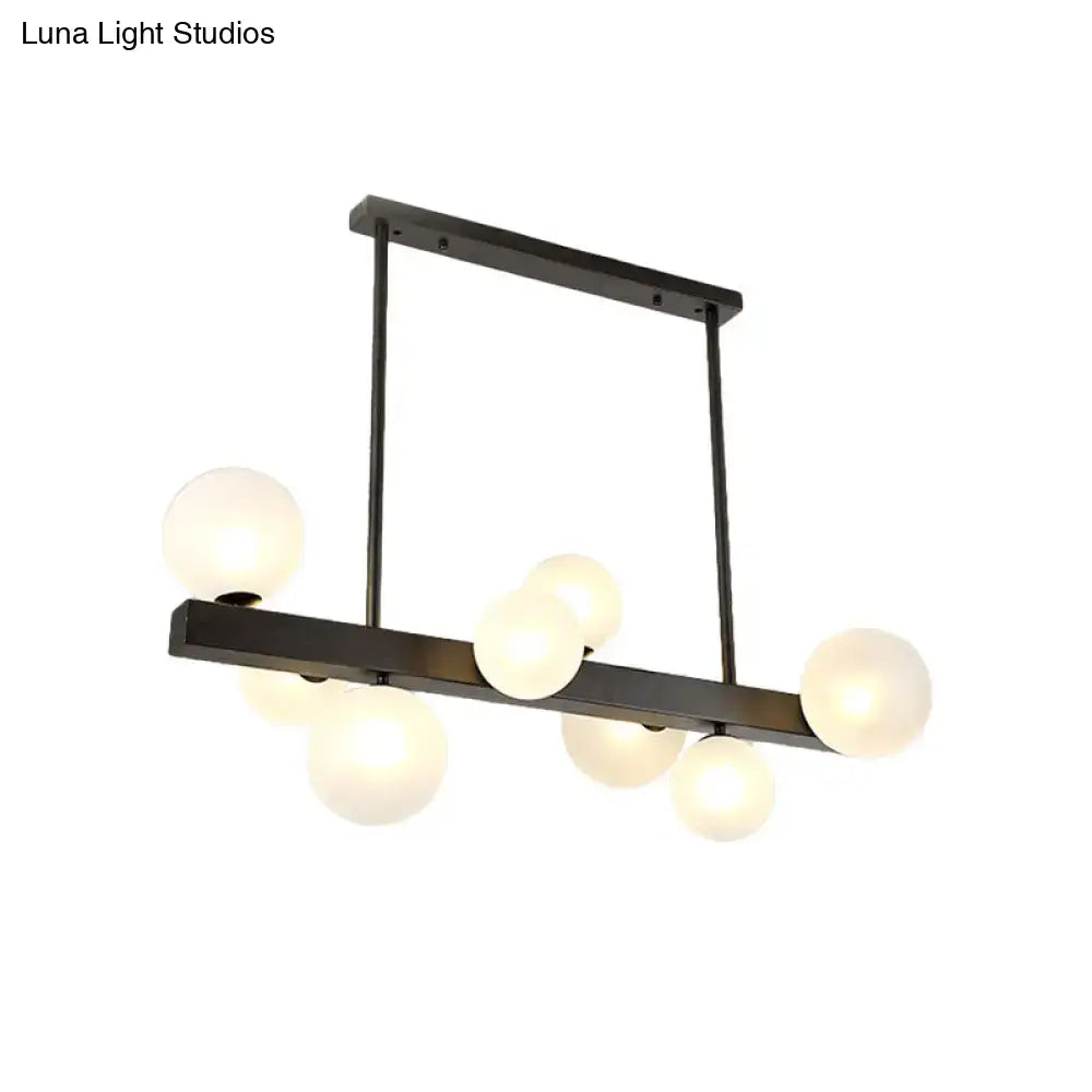 Modern black metal chandelier with frosted glass globe bulbs for dining room and kitchen island lighting by DecorBites