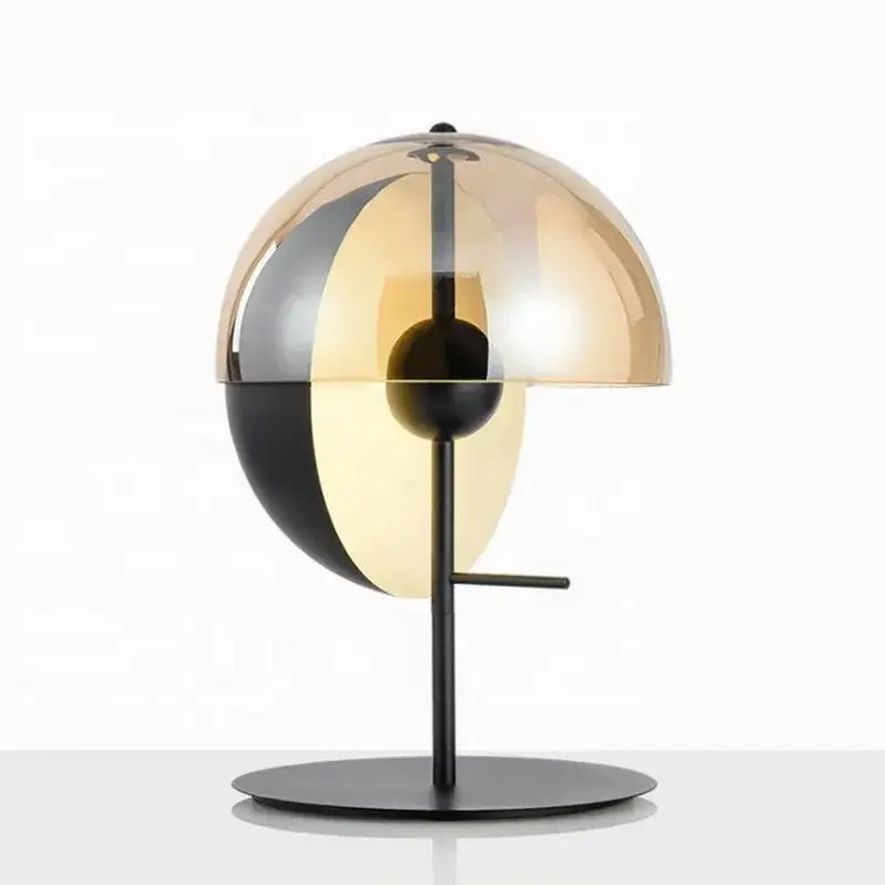 A modern black glass designer bedside lamp with split dome amber and mirrored black glass on a matte black base