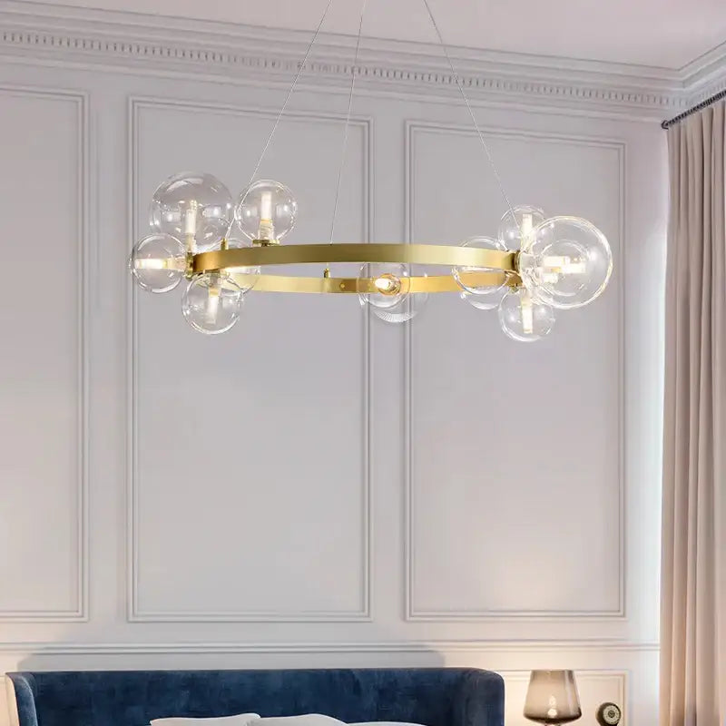Modern gold-toned circular pendant light fixture with clear glass globe bulbs for dining room use