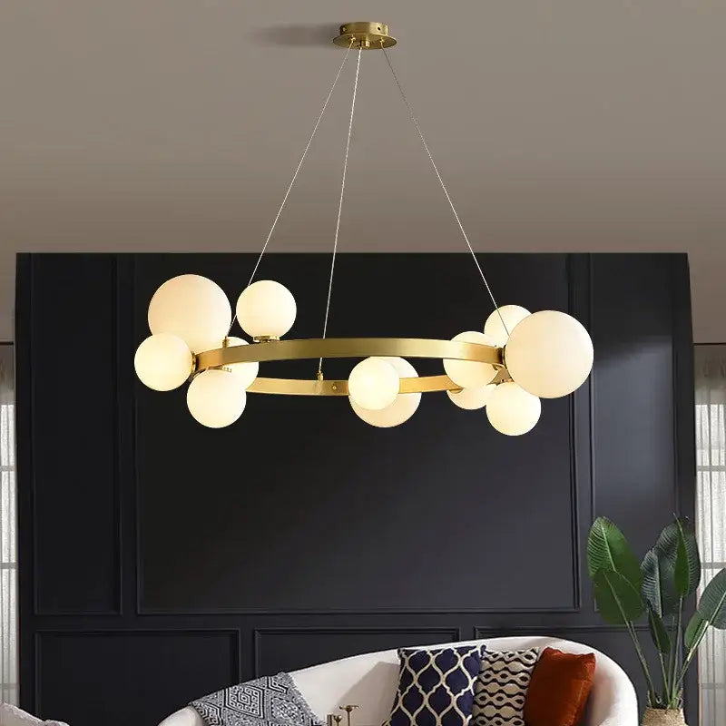 Modern gold-toned pendant light fixture with circular frame and frosted glass globes for dining room lighting