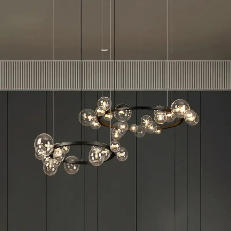 Modern black metal pendant light fixture with clear glass globe bulbs in overlapping circular rings for dining room