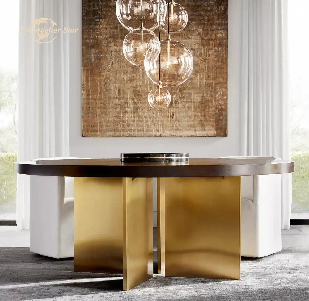 Modern round dining table with dark wood top and brushed gold legs paired with decorbites glass globe pendant light