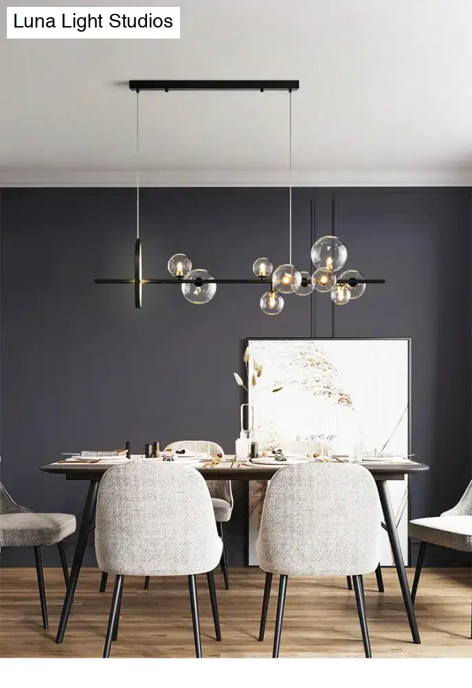Modern black metal chandelier with clear glass globe bulbs designed as a dining table pendant light with bulb base