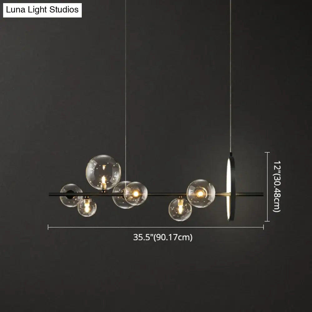 Modern black glass globe pendant light with clear glass bulb base and sleek metal design for dining table lighting