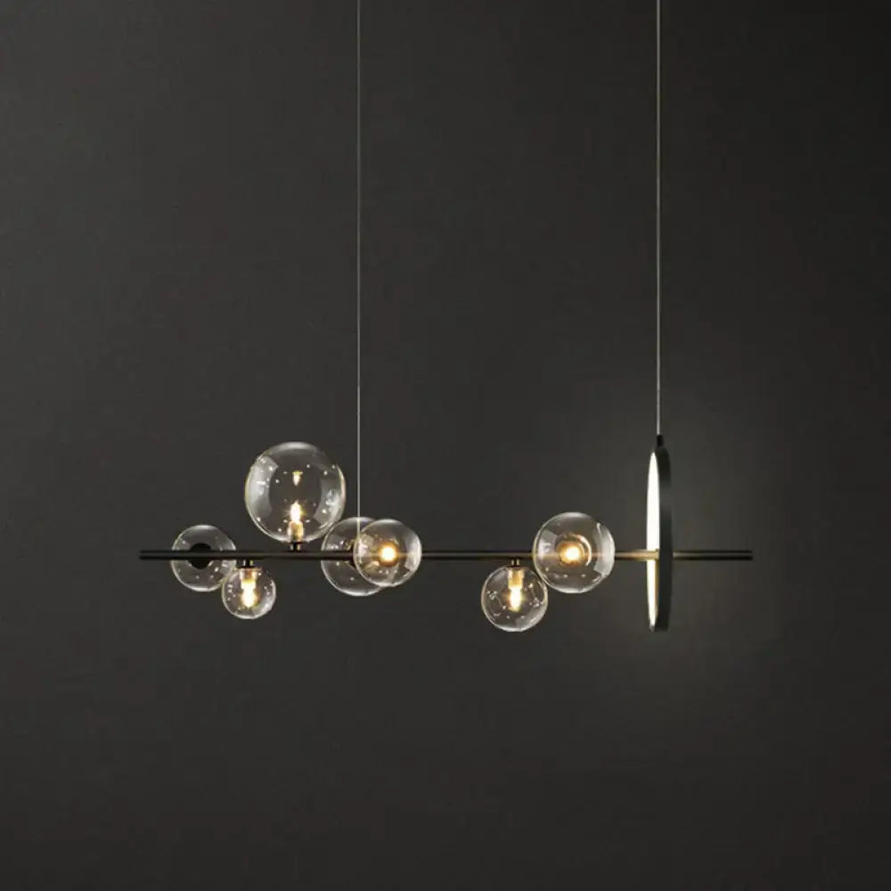 Modern black glass globe pendant light with clear bulb base and minimalist metal design for dining table illumination