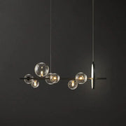 Modern black glass globe pendant light with clear bulb base and minimalist metal design for dining table illumination