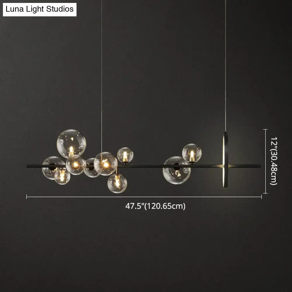 Modern black glass globe pendant light with clear bulb base and metal fixture designed for dining table illumination