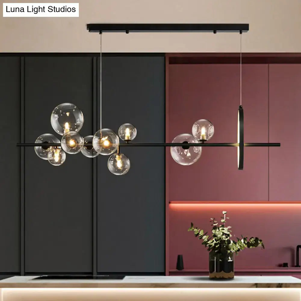 Modern black glass globe pendant light with clear bulb base and sleek horizontal bar design for dining table illumination