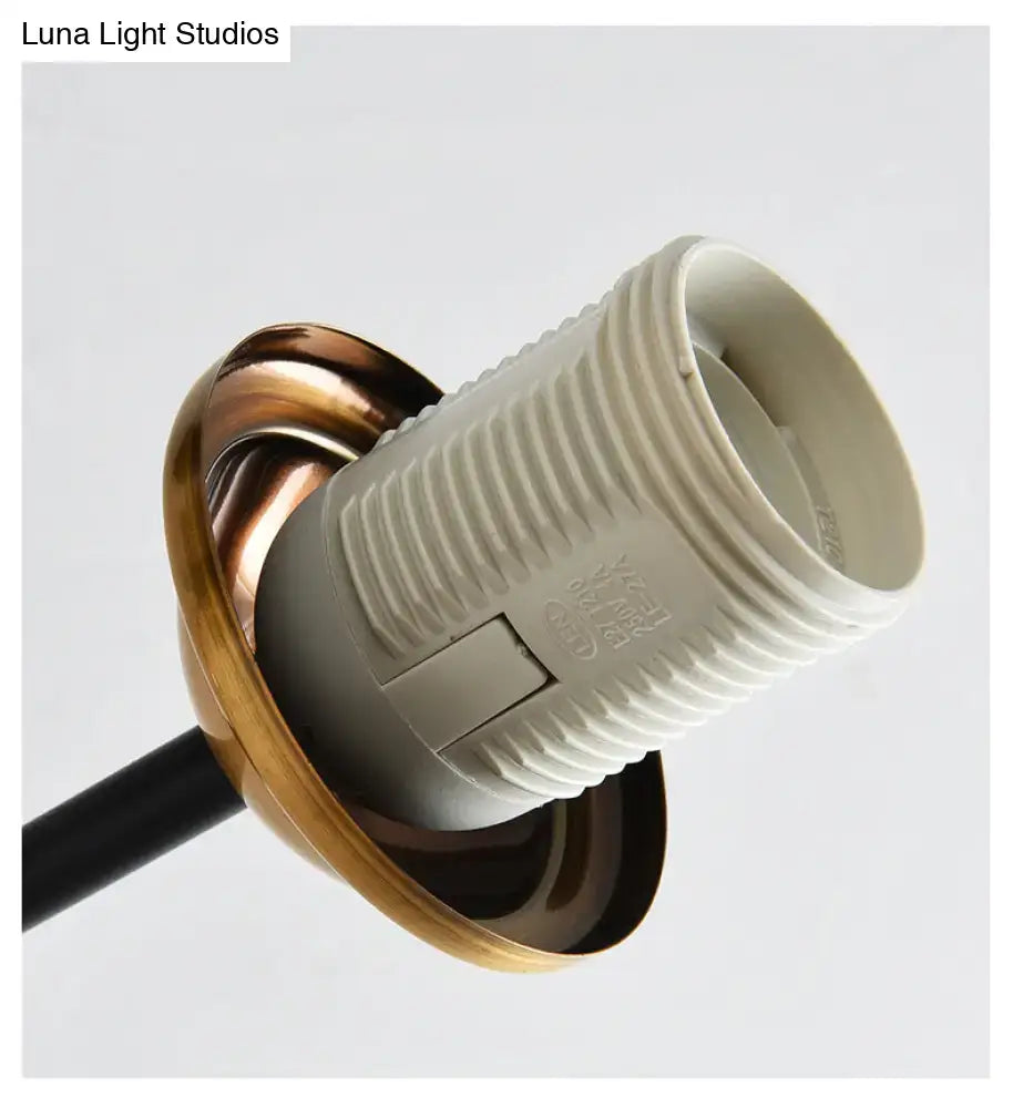 A modern black island pendant light with a brass dining room base featuring a white plastic lamp socket with switch