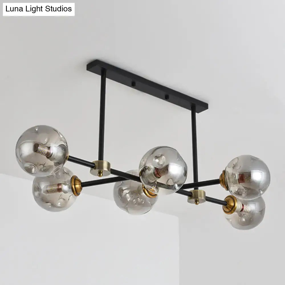 Modern black island pendant light with six clear glass globe bulbs and brass accents for dining room lighting
