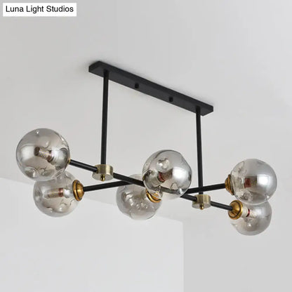 Modern black island pendant light with six clear glass globe bulbs and brass accents for dining room lighting