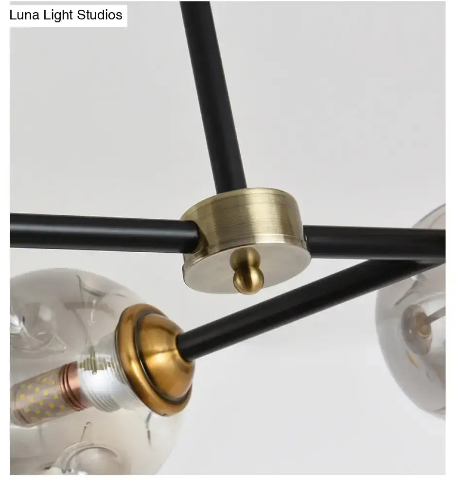 Modern black island pendant light with brass and spherical glass bulbs for dining room featuring stained glass accents