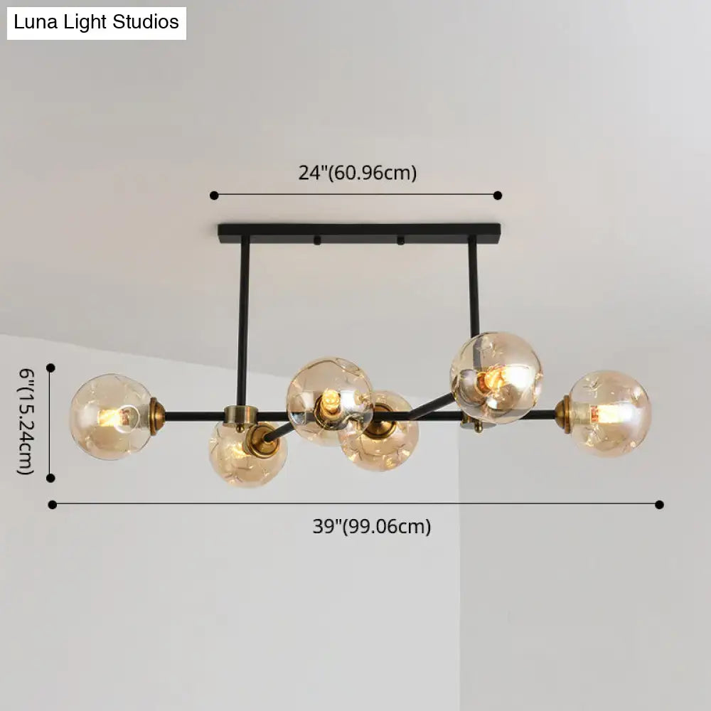 Modern black glass island pendant light with brass frame featuring five spherical bulbs for dining room lighting