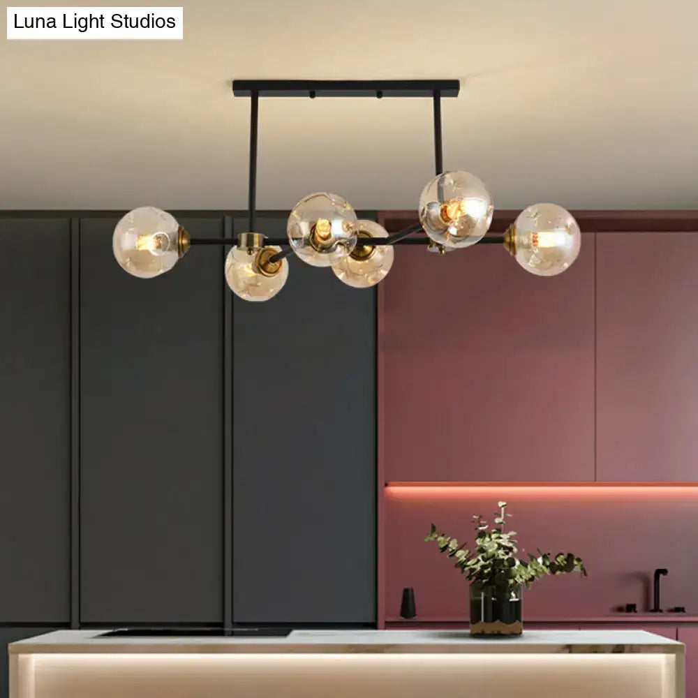 Modern black glass island pendant light with brass accents and clear glass globe bulbs for dining room illumination