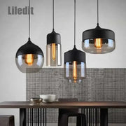 Set of three modern black glass pendant lights with smoked shades and warm filament bulbs for dining room decorbites black glass