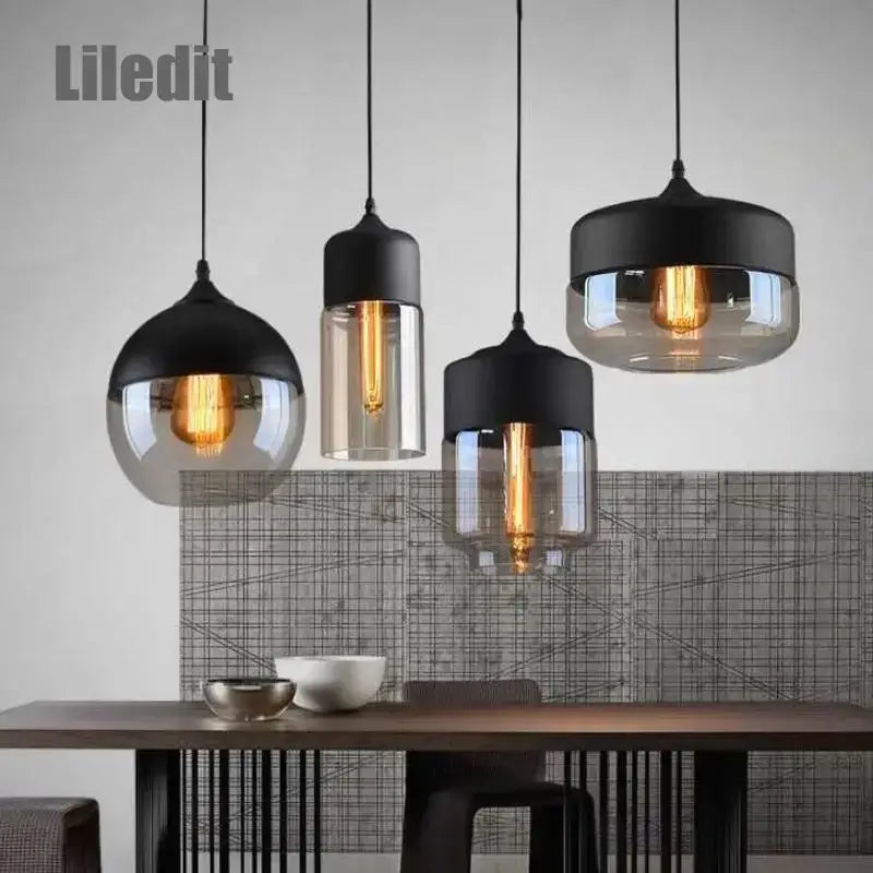 Set of three modern black glass pendant lights with smoked shades and warm filament bulbs for dining room decorbites black glass