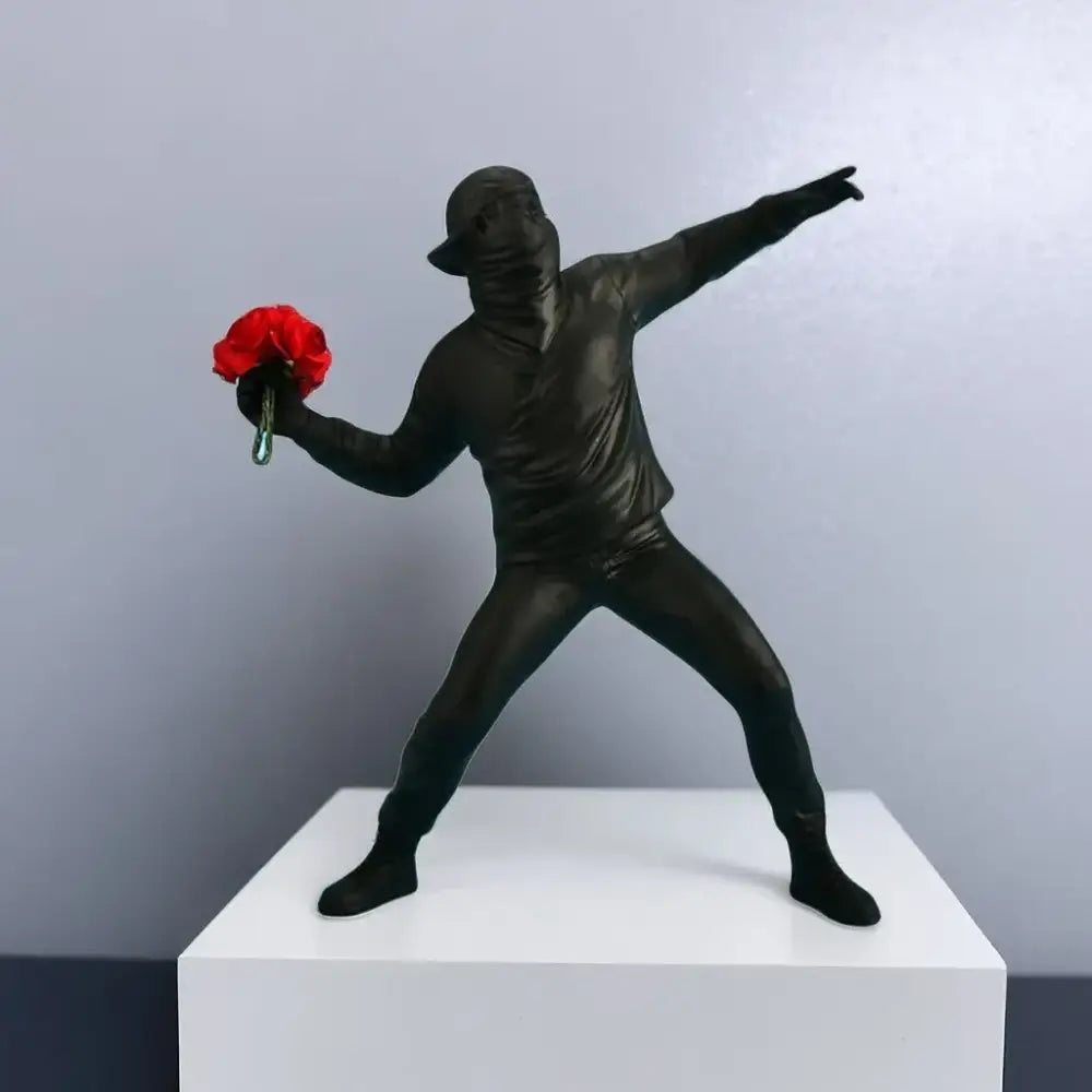 Black glossy bansky flower thrower sculpture of person in dab pose holding red roses modern office decor