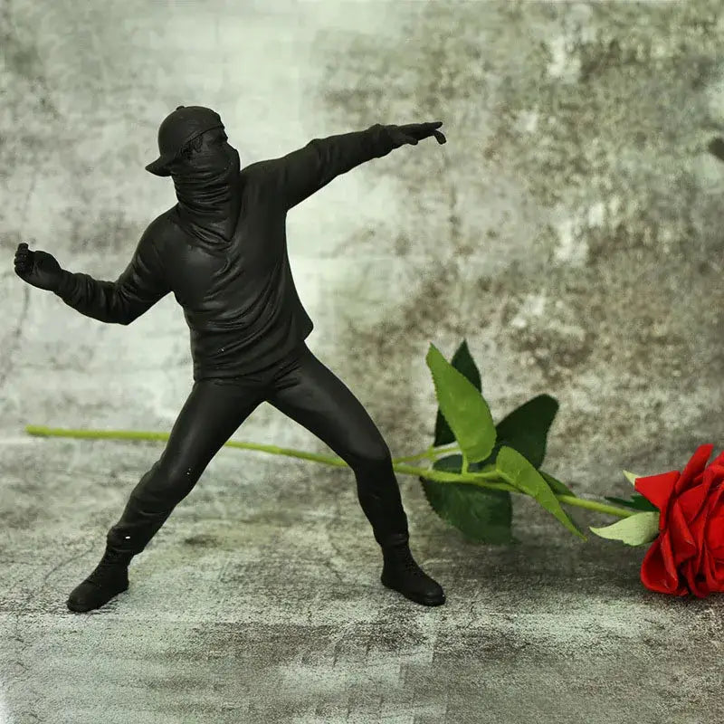 Black plastic bansky flower thrower sculpture in a dynamic pose with glossy finish for modern office decor