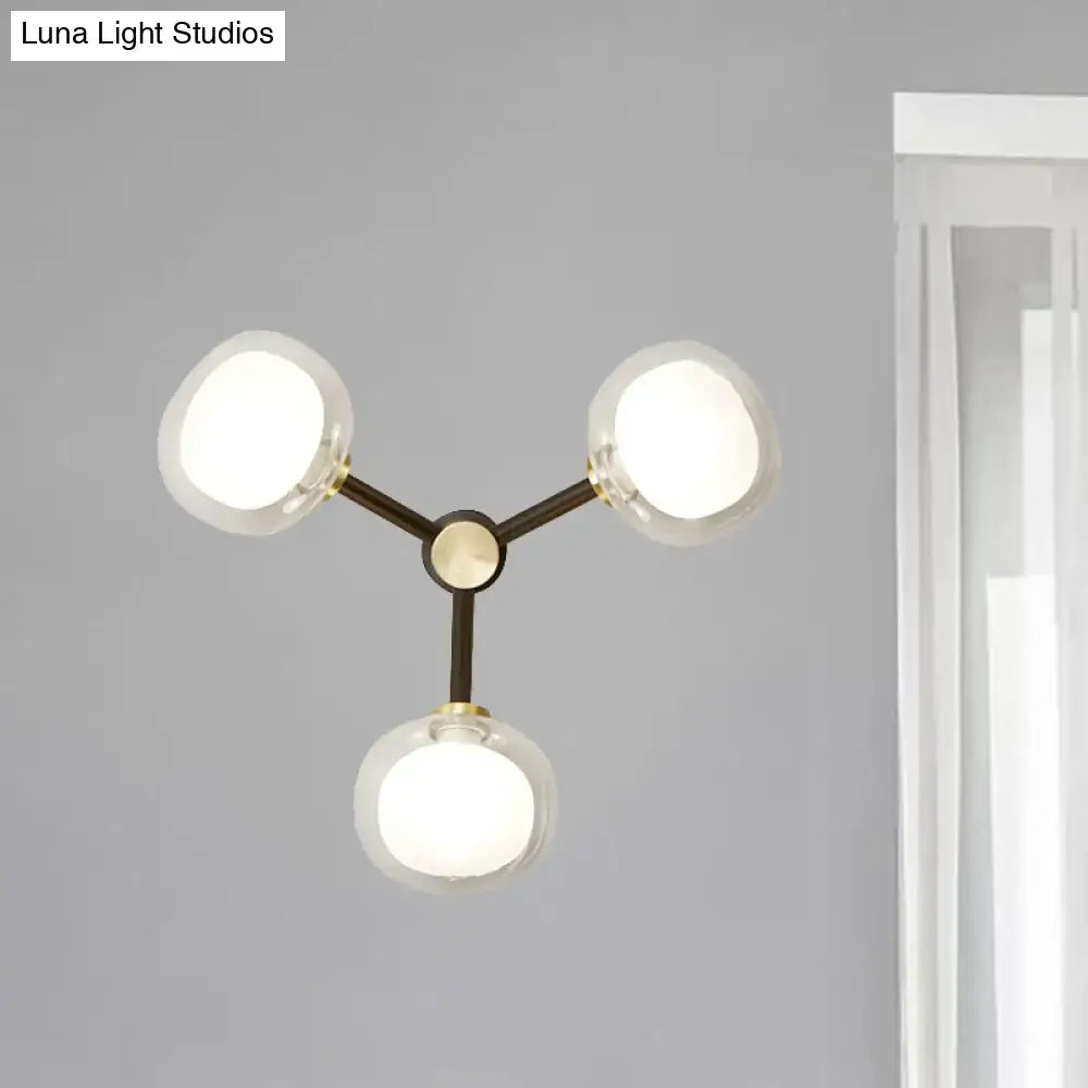 Modern black and gold three-light wall lamp with clear glass shade and matte black metal frame for bedroom lighting
