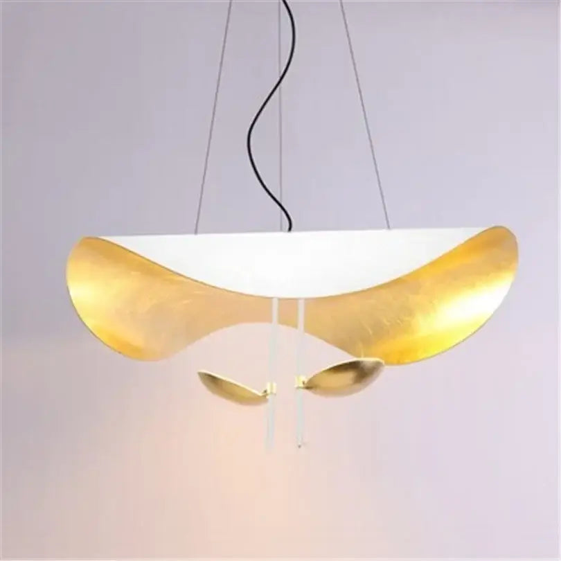 A modern black and gold abstract pendant lamp with curved design and hanging leaf accents for dining room decorbites lederam manta pendant