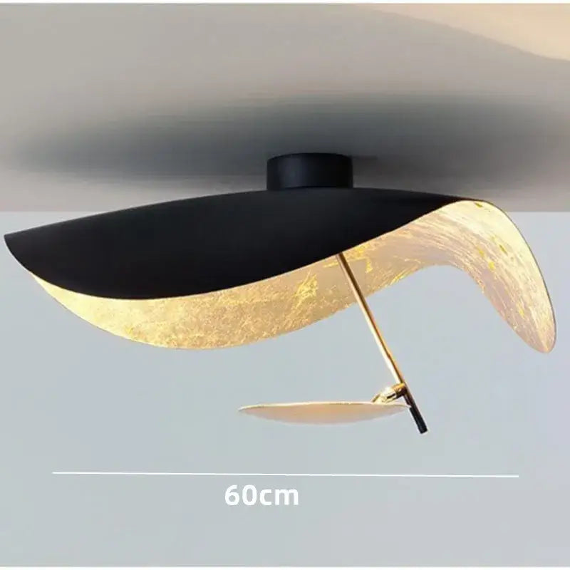 Modern black and gold abstract pendant lamp with sleek outer shell and leaf-like inner design for dining room decorbites lederam manta pendant
