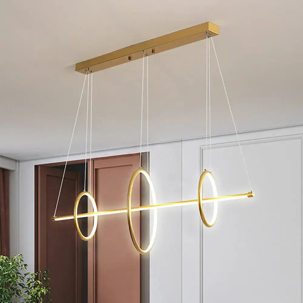Gold-toned DecorBites™ modern acrylic linear suspension light with three glowing rings for island pendant lighting