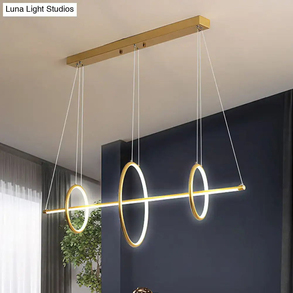 Modern gold-toned acrylic linear suspension light with three glowing rings for island pendant lighting by DecorBites