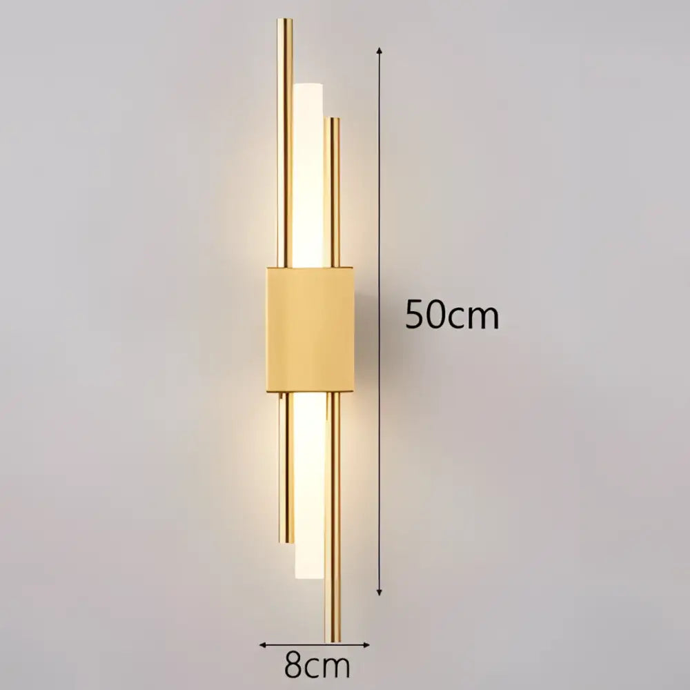 Modern black and gold acrylic pipe wall lamp featuring a gold-toned sconce with sleek vertical bars and warm light