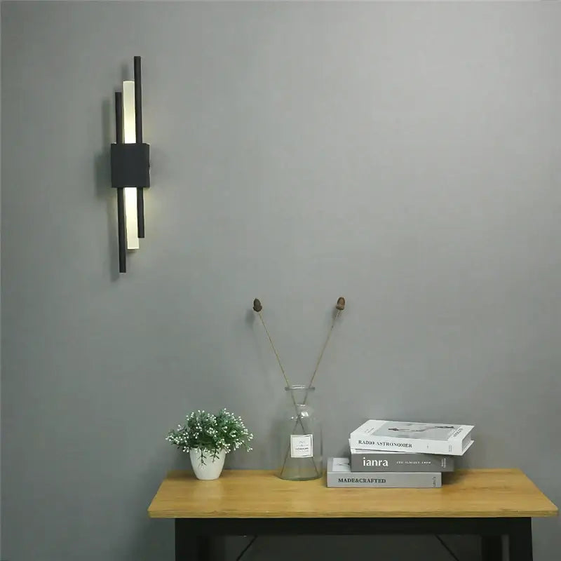 Modern black and white wall lamp featuring sleek vertical bars and gold acrylic pipe for bedroom sconce lighting