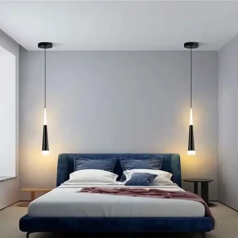 Modern black and gold aluminum cord pendant light with sleek tapered design hangs above the bedroom bed