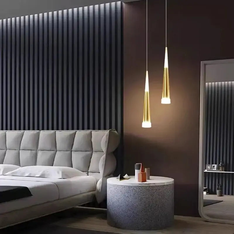 Two sleek gold-toned aluminum cord pendant lights with tapered shades for modern bedroom lighting