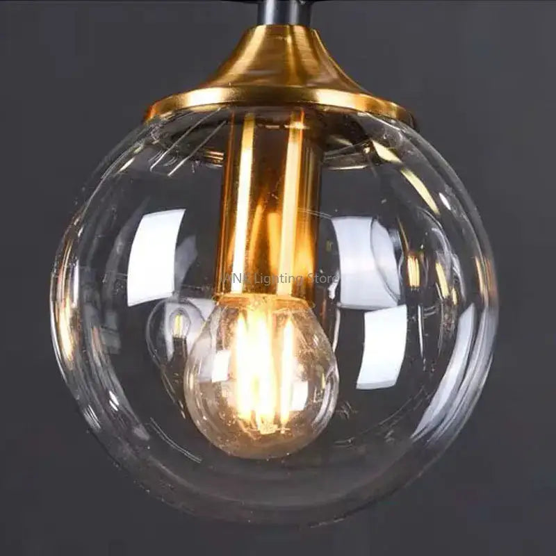 Modern black and gold glass pendant lights with spherical glass and brass finish for dining room illumination
