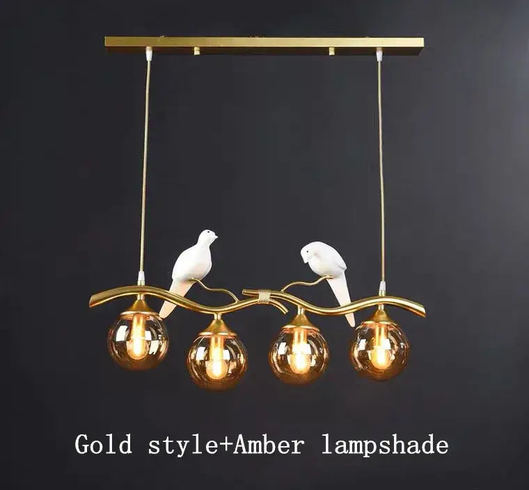 Modern black and gold glass pendant lights featuring gold-toned branch design with white ceramic doves and amber globes