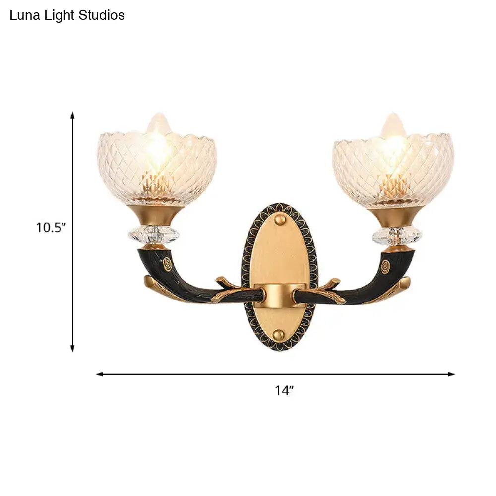 Modern black and gold metal black sconce with two clear prismatic glass shades for bedroom lighting