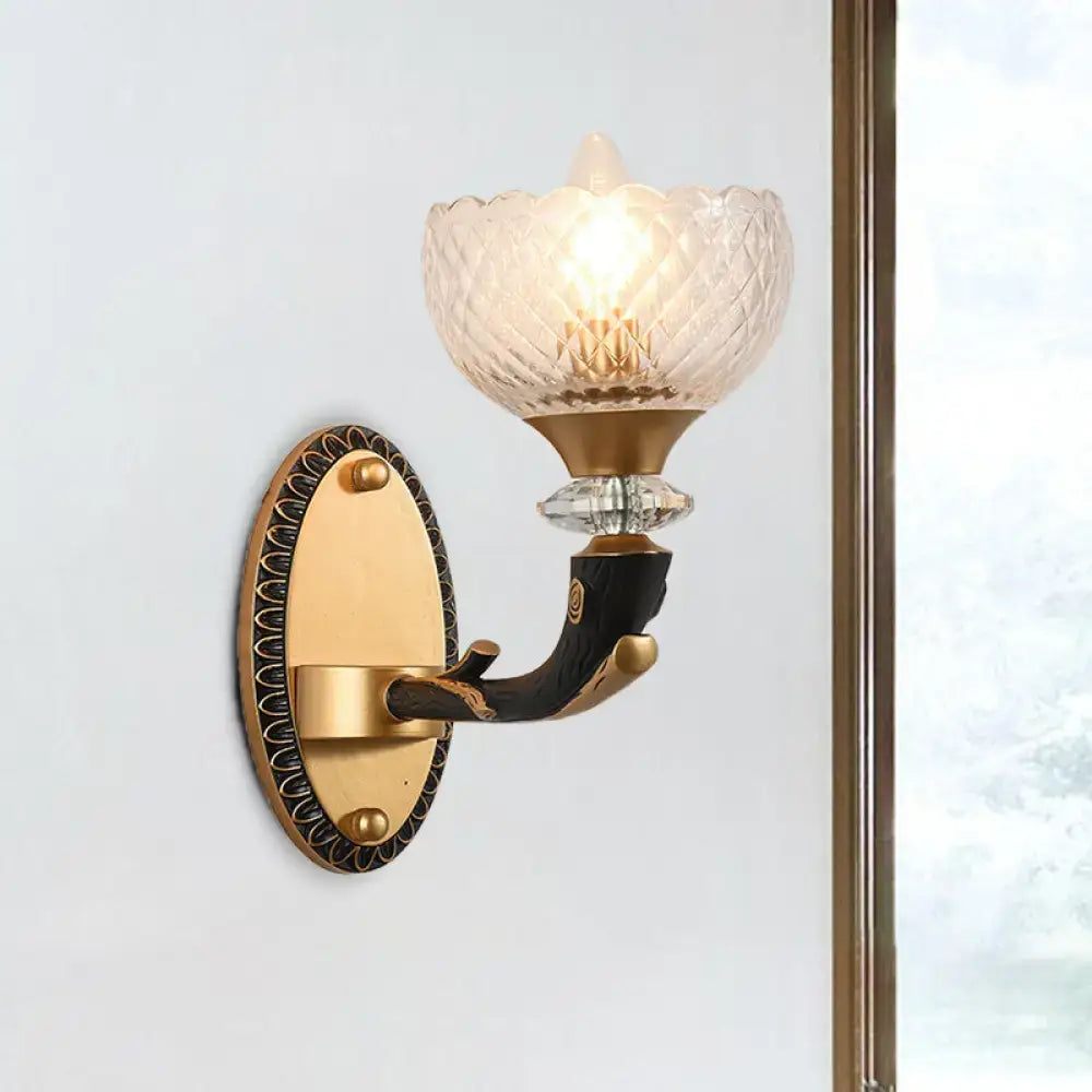 Gold-toned metal black sconce with a branch-like arm and clear prismatic glass shade for modern bedroom lighting