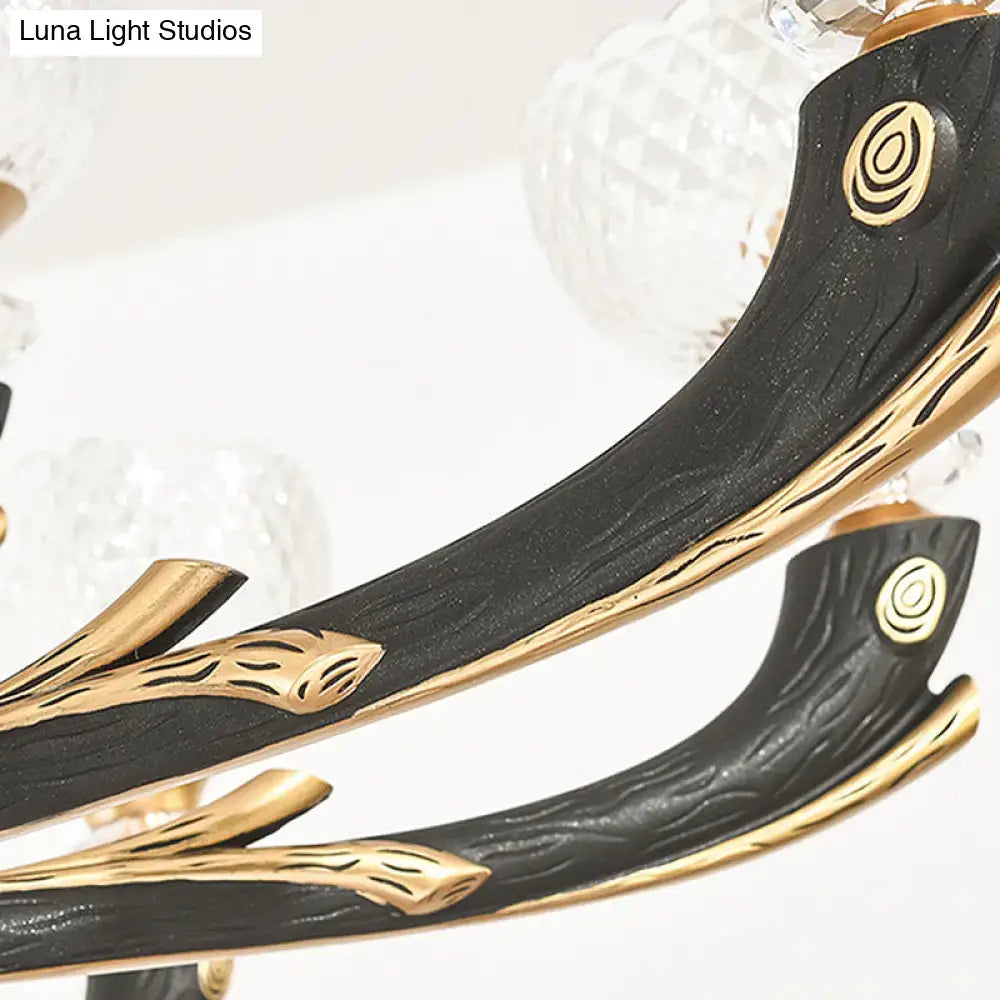 Modern black and gold metal black sconce with wood grain texture and clear prismatic glass shade for bedroom use