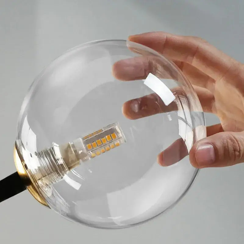 Modern black and gold branching bubbles chandelier featuring a clear glass globe lamp with a gold-toned metal base and led bulb