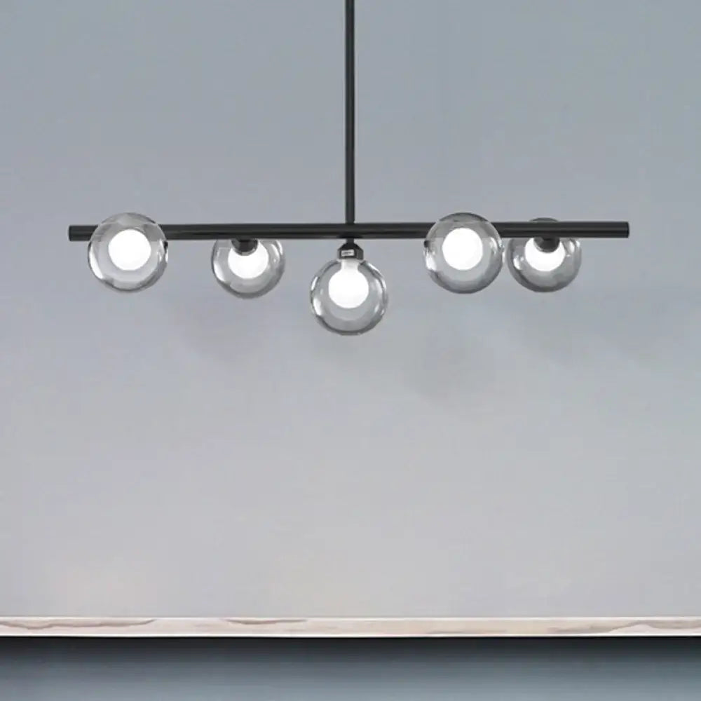 Modern black metal ceiling light with five bubble clear glass globe bulbs for a clear glass island dining room