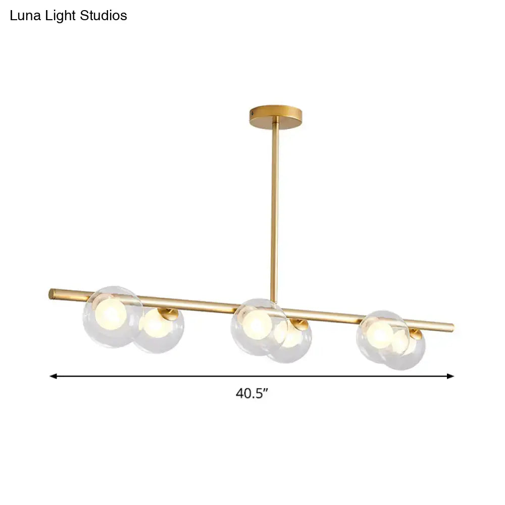 Modern black and gold ceiling light with gold-toned bar and three bubble clear glass shades for dining room island use