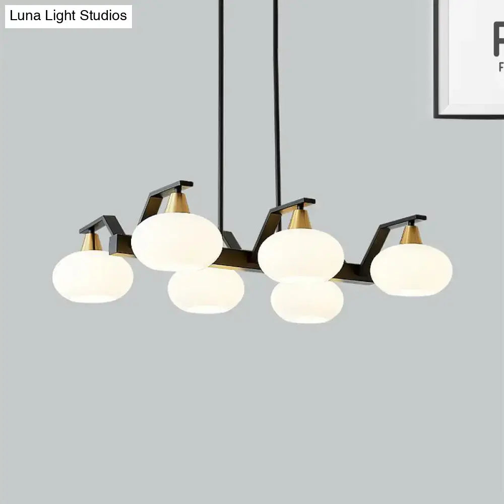 Modern black and brass pendant light with five frosted white oval glass shades suitable for 220v-240v fixture height