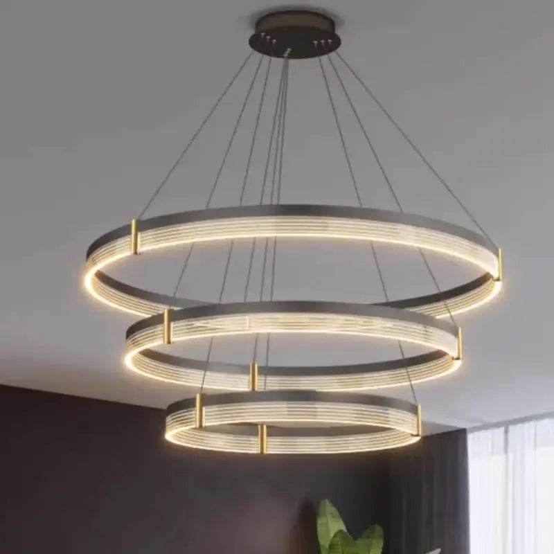 Modern black and gold three-tiered pendant light with sleek black acrylic led rings for stylish living room decorbites lighting