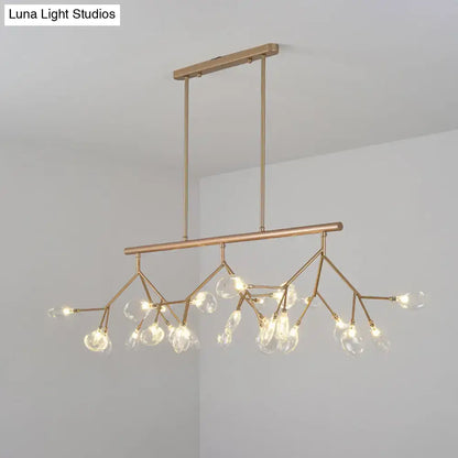 A modern black and gold dining room chandelier with clear glass globe bulbs and a brass-toned branching design