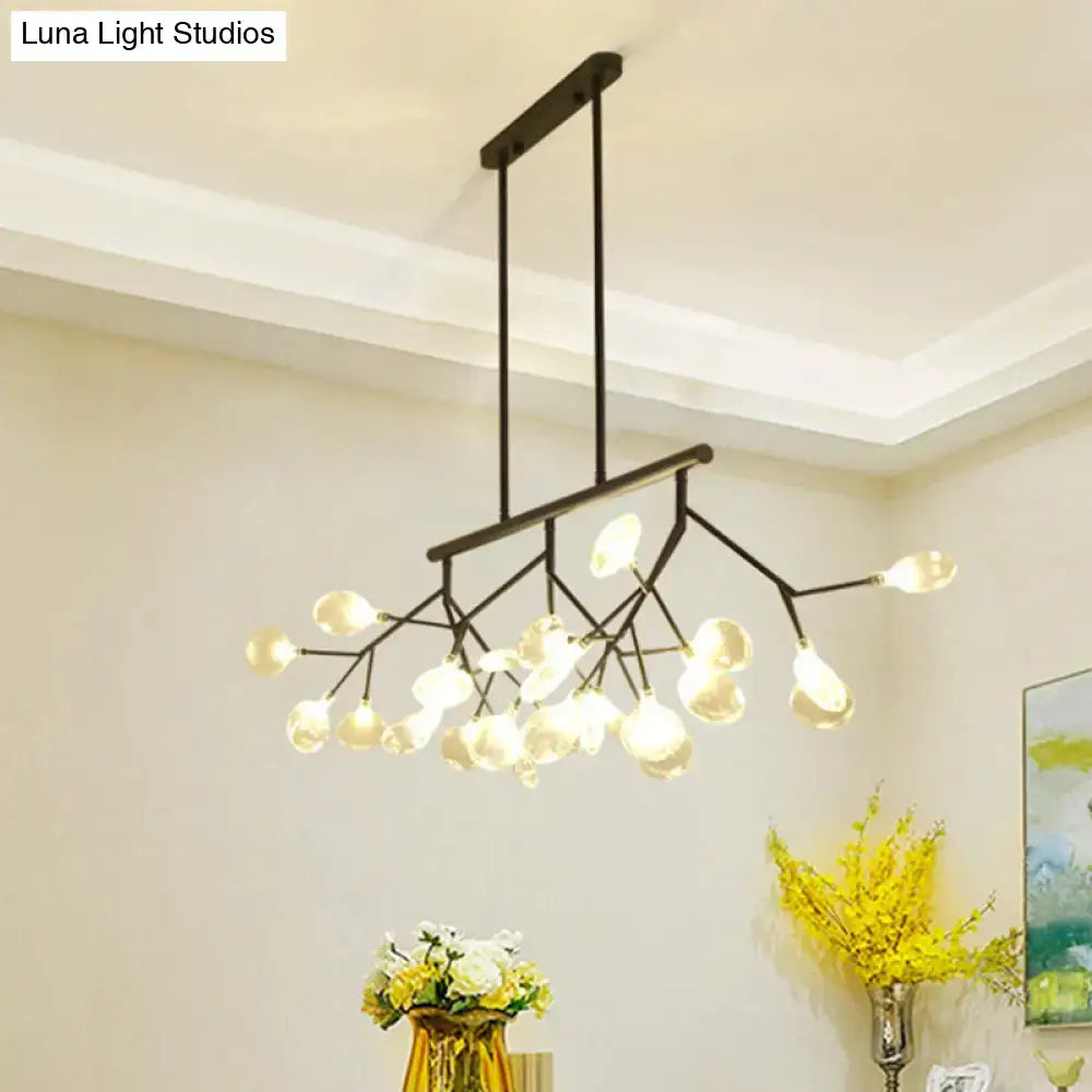 Modern black and gold chandelier with branching arms and clear glass teardrop bulbs for dining room lighting