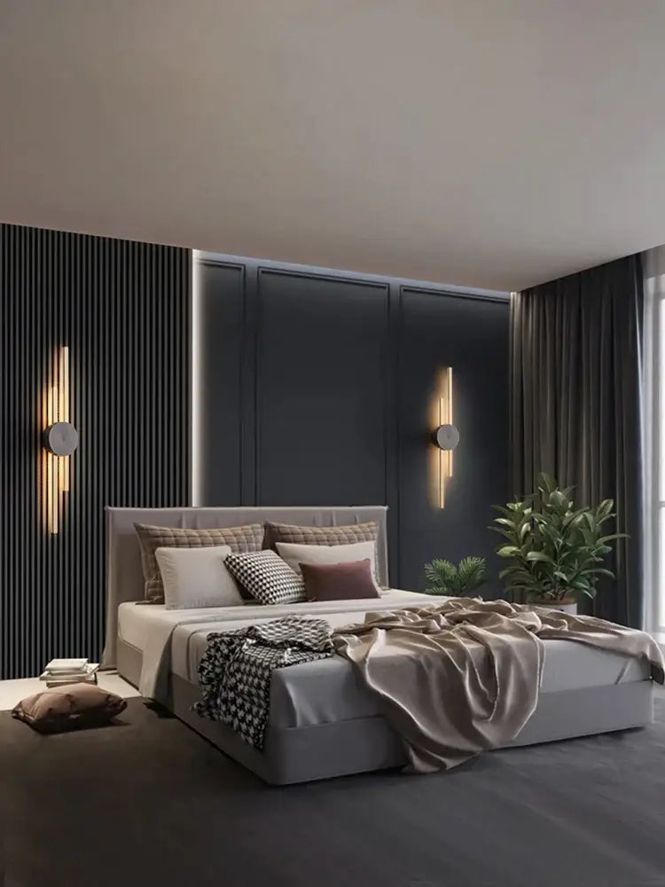 Modern gray upholstered bed with tufted headboard and layered bedding featuring modern black and gold decorbites copper wall light sconce