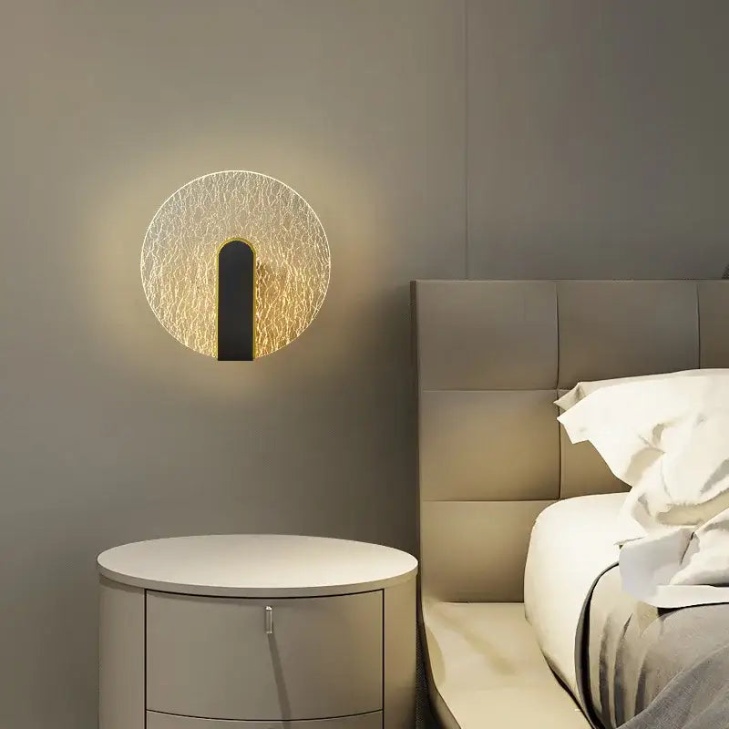 Modern black and gold led wall lamp with textured crackled glass face and warm golden glow for bedroom lighting