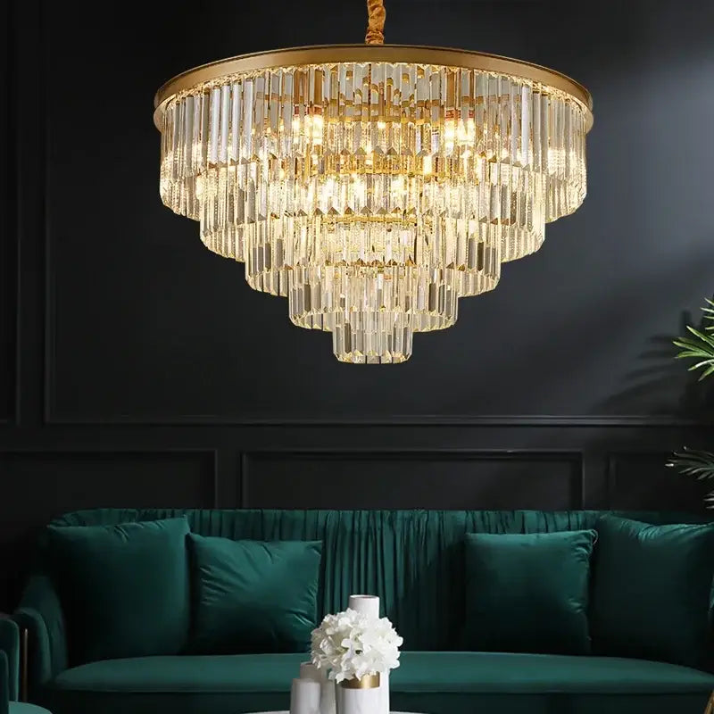 Modern black and gold crystal ceiling chandelier with clear glass rods above an emerald green velvet sofa